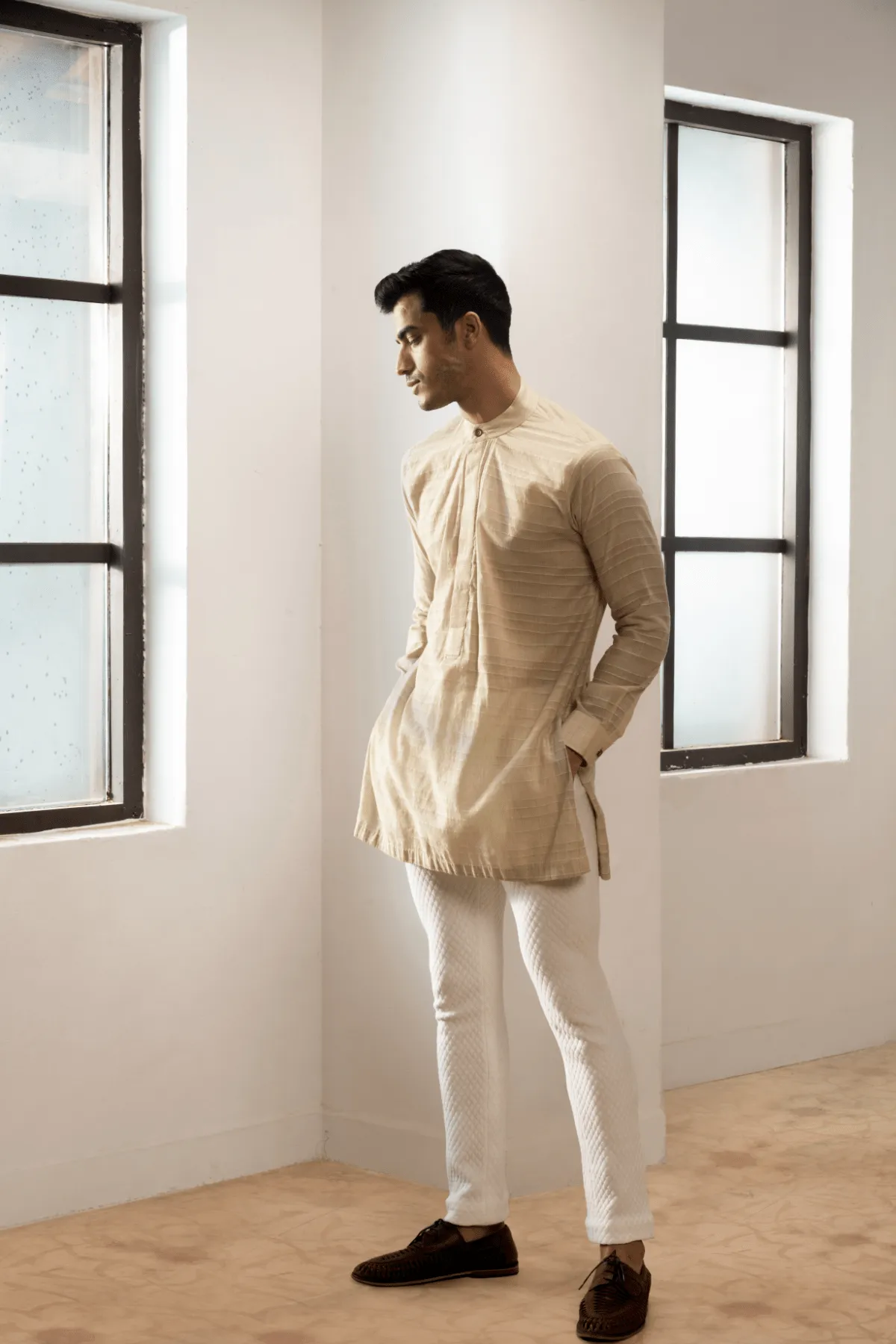 Ivory textured jacket with  off white kurta and white pants.