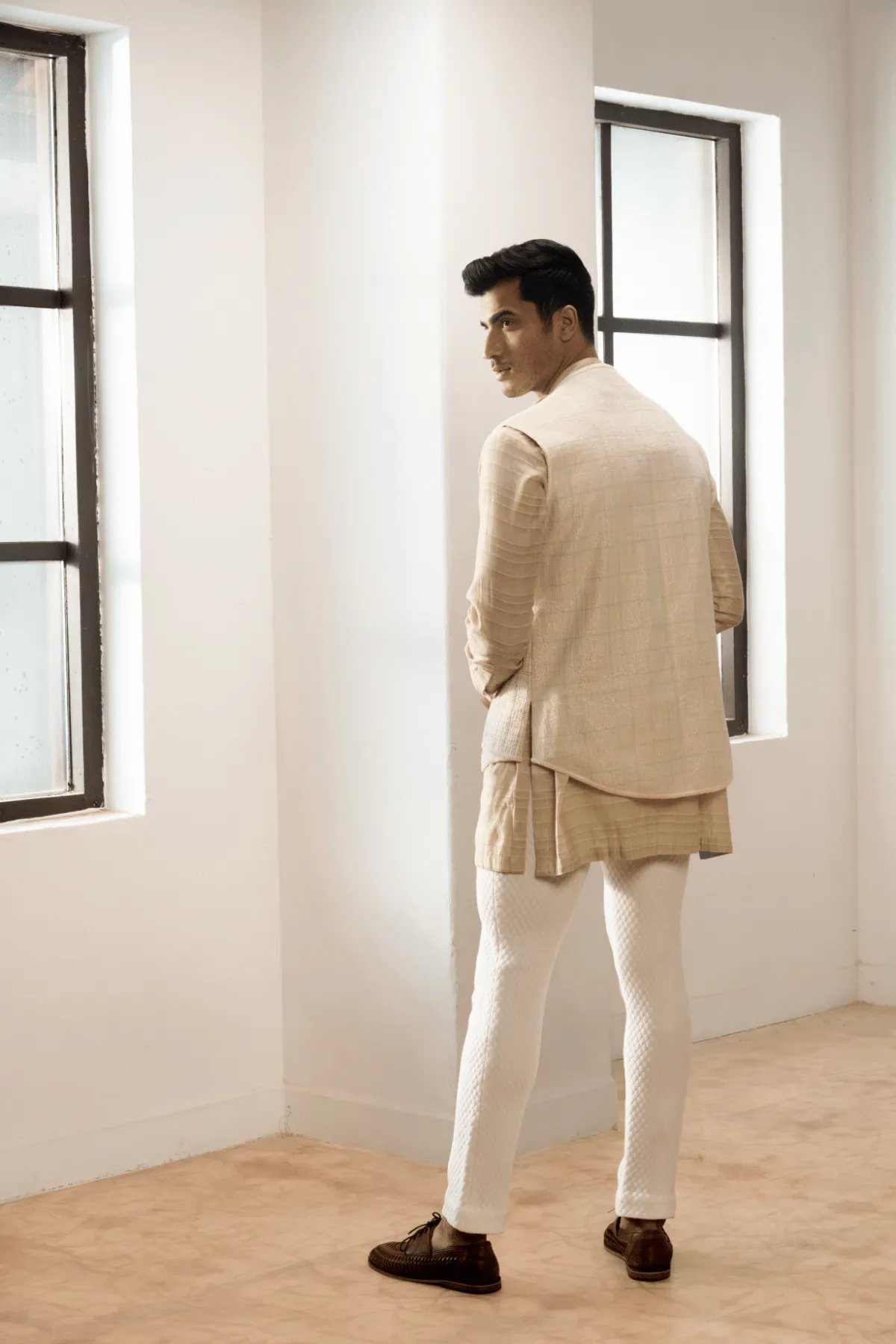 Ivory textured jacket with  off white kurta and white pants.