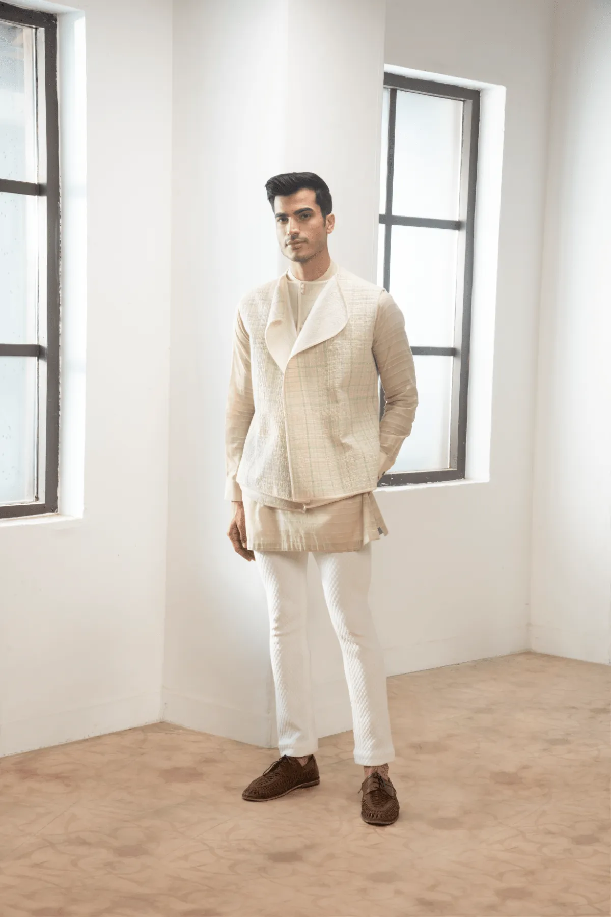 Ivory textured jacket with  off white kurta and white pants.