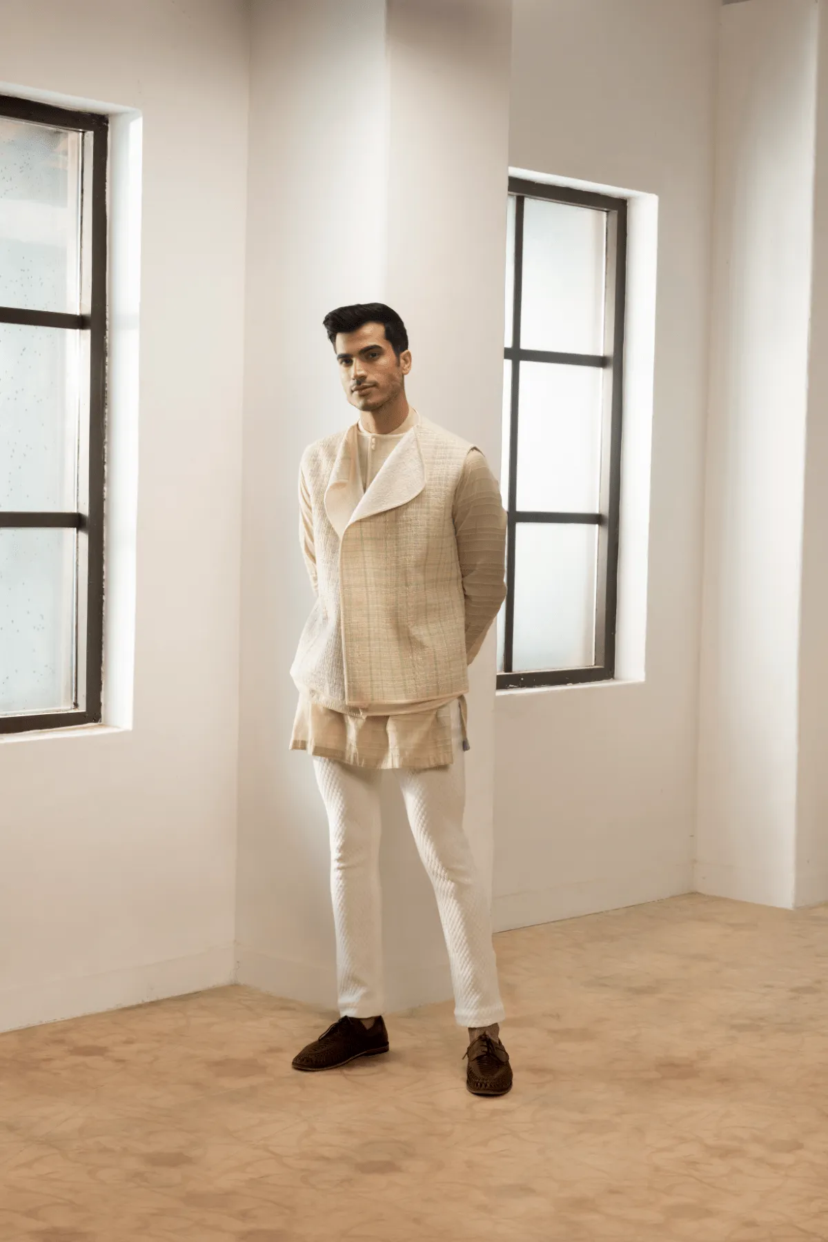 Ivory textured jacket with  off white kurta and white pants.